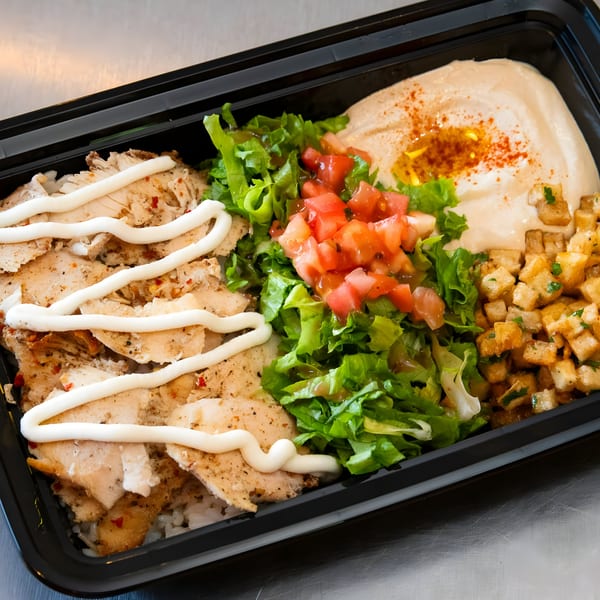Shawarma Mediterranean Grill's chicken shawarma plate with hummus, salad, and potatoes in a black container.